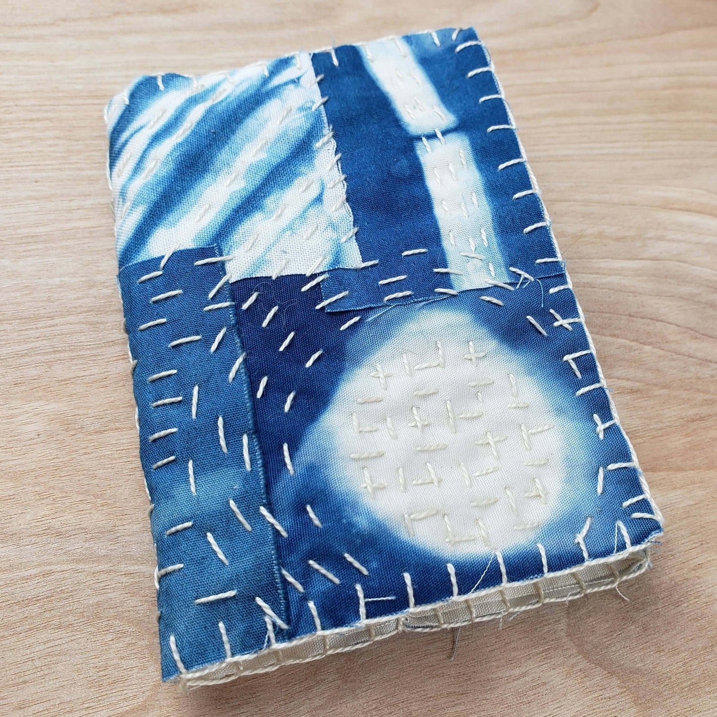 Boro sewing kit needle book with natural indigo dyed fabric and visible stitching.