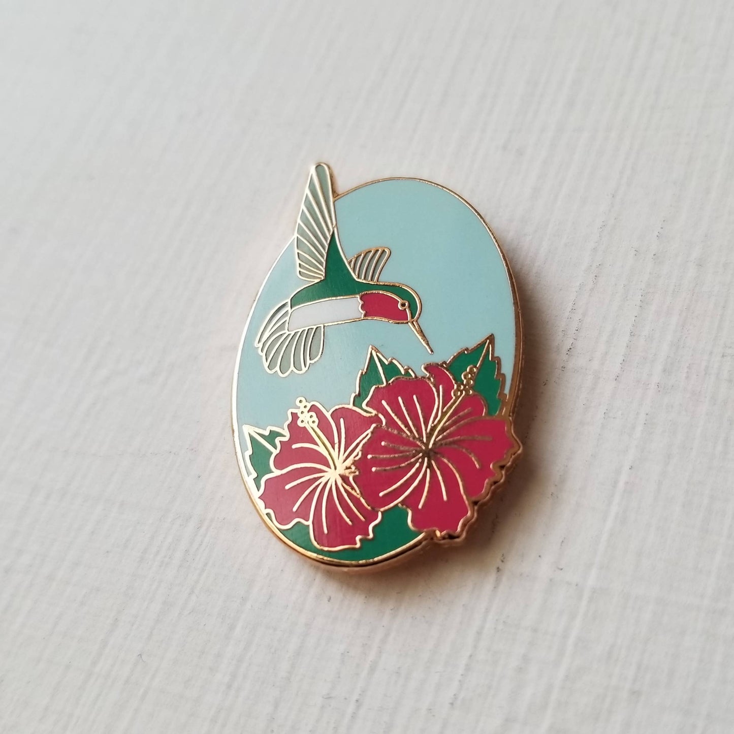 Hummingbird Enamel Needle Minder with floral design, magnetic needle holder in hard enamel with copper plating.