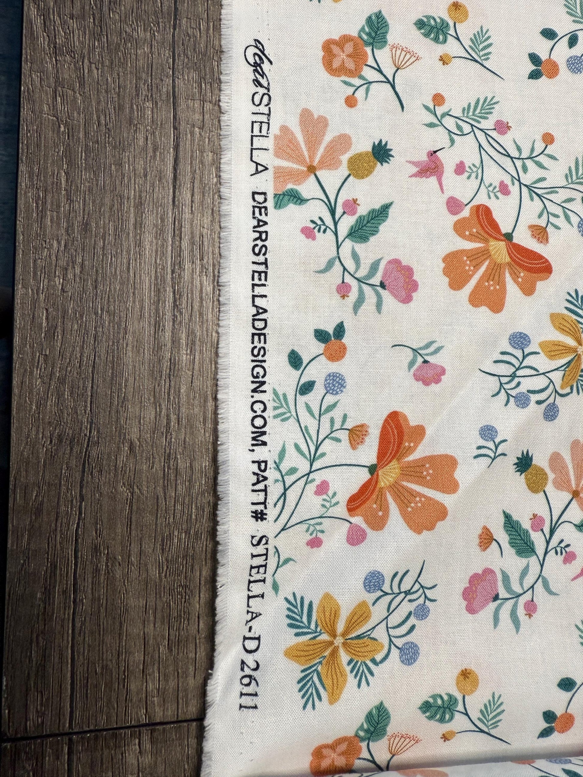 Dear Stella White Cotton Fabric D2611 with floral pattern on a wooden surface